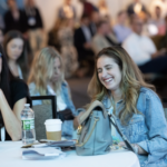 Two attendees at CommerceNext sit and chat with each other.